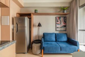 een woonkamer met een blauwe bank en een koelkast bij BHomy V Nova Conceição - Moderno e novo NX1017 in Sao Paulo