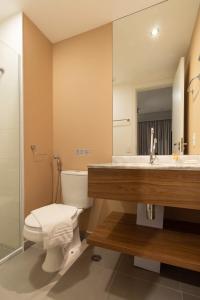 een badkamer met een toilet, een wastafel en een spiegel bij BHomy V Nova Conceição - Moderno e novo NX1017 in Sao Paulo