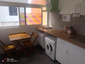 eine Küche mit einer Waschmaschine und einem Tisch in der Unterkunft Apartamentos Doña Carmen in Los Silos