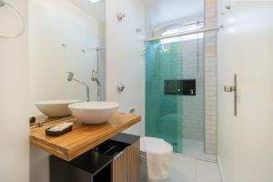 baño con 2 lavabos y ducha de cristal en BHomy Rua Antônio Carlos 196, en São Paulo