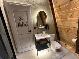a bathroom with a toilet and a sink and a mirror at PeaksView Chalets in Žabljak