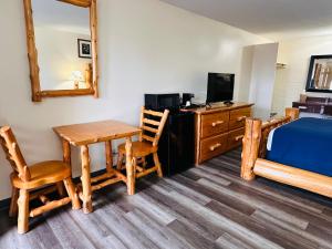a room with a table and a bed and a desk at Northwoods Motel in Blaine