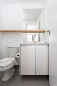 a white bathroom with a toilet and a sink at BHomy V Nova Conceicao - Suíte e varanda NX1409 in Sao Paulo