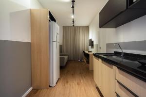 uma cozinha com um lavatório e um frigorífico em BHomy Consolacão - Espacoso e completo CP 2205 em São Paulo