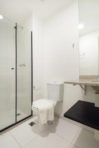 uma casa de banho branca com um WC e uma cabina de duche em vidro. em BHomy Consolacão - Espacoso e completo CP 2205 em São Paulo