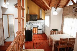 Patagonia Hostel في إل تشالتين: مطبخ مع ثلاجة وطاولة في الغرفة