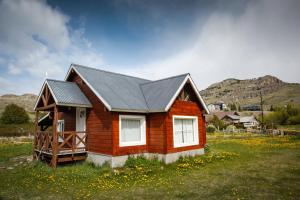 a small wooden house in a field of flowers at Patagonia Hostel in El Chalten