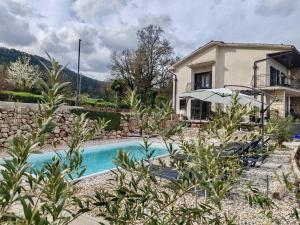 a villa with a swimming pool in front of a house at Apartment Aria in Lovran