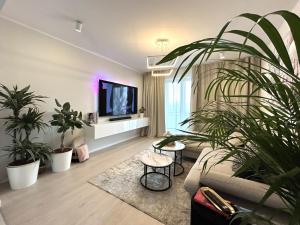 a living room with a couch and a tv and plants at Apartment Aria in Lovran