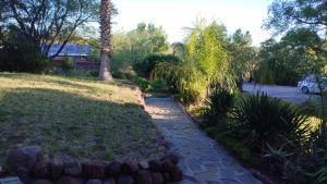 a garden with a stone path and a palm tree at Uitzight in Beaufort West