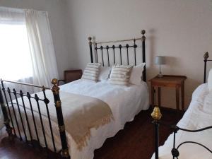 a bedroom with a large bed with white sheets and pillows at Uitzight in Beaufort West