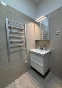 La salle de bains est pourvue d'un lavabo et d'un miroir. dans l'établissement White House Apartman Siófok, à Siófok