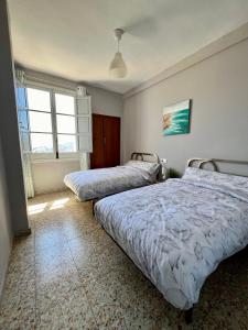 een slaapkamer met 2 bedden en een raam bij Vitalba Apartments in Lanjarón