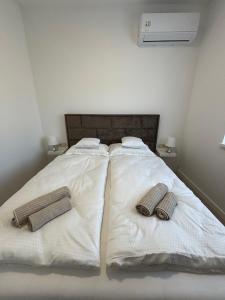 - un lit avec 2 serviettes et 2 oreillers dans l'établissement White House Apartman Siófok, à Siófok