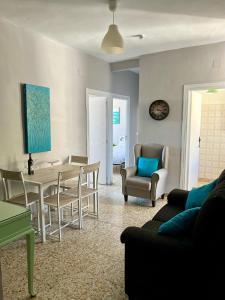 un soggiorno con tavolo da pranzo e sedie di Vitalba Apartments a Lanjarón
