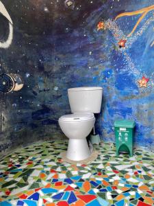 a bathroom with a toilet in front of a mural at Casa Azulverde Palomino - Breakfast Inclusive in Palomino