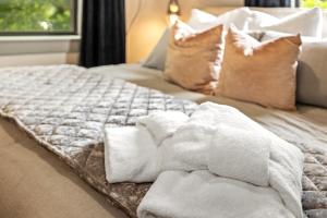a bed with white towels on top of it at Apt on Town Square - Ultimate DT Fay Location in Fayetteville