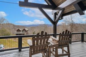 two chairs on a deck with a view of the mountains at Mountain View Manor in Banner Elk