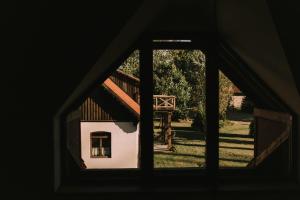 a view of a house through a window at Poganty - Jałownik in Giżycko