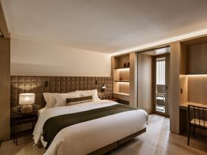 Pulso Hotel Faria Lima في ساو باولو: غرفة نوم كبيرة مع سرير كبير ونافذة