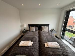 um quarto com duas camas com almofadas em Luxury Furnished 2 Bed Northampton apartment with Balcony near NN5 stadium em Northampton