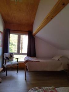 a bedroom with a bed and a chair and a window at Posada Al Río in Isla de Maipo
