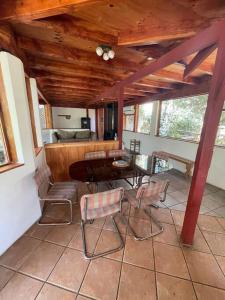 een veranda met een tafel en stoelen en een keuken bij Posada Al Río in Isla de Maipo