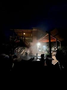 Eine Gruppe von Menschen, die nachts am Tisch sitzen in der Unterkunft Posada Al Río in Isla de Maipo