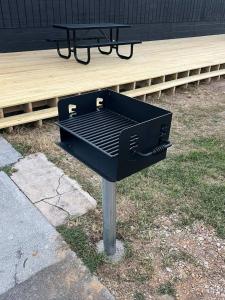 a black barbecue grill with a picnic table in the grass at Wildflower Room At The Trailblazer Unit 10 in Townsend