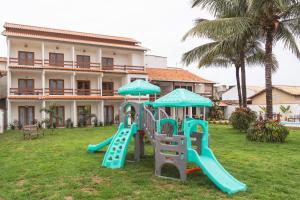 um parque infantil em frente a um edifício com escorregas em Casa Dela Pousada em Cabo Frio