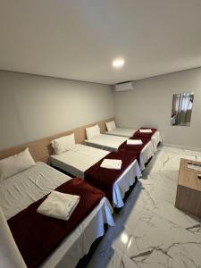 uma fila de camas num quarto com pisos em mármore em Hotel Fênix Belenzinho em São Paulo