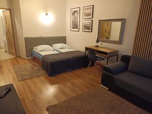 sypialnia z łóżkiem, biurkiem i kanapą w obiekcie Domek Całoroczny Aga w mieście Mikołajki
