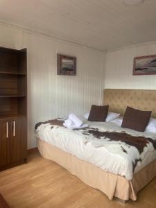 een slaapkamer met een groot bed in een kamer bij Hostal Queltehue in Ancud