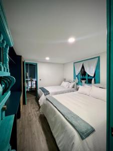 1 dormitorio con 2 camas y ventana en Hotel Club el Llano, en Combita