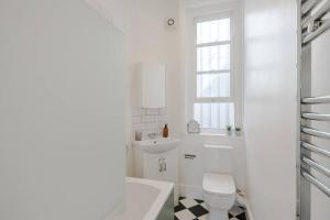 a white bathroom with a toilet and a sink at The Highlife Holborn in London