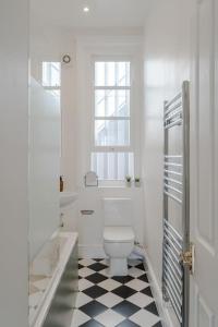 a bathroom with a toilet and a black and white checkered floor at The Highlife Holborn in London
