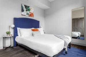 um quarto com uma cama branca e uma cabeceira azul em Bengals and Reds just minutes away em Cincinnati