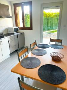 een keuken met een tafel met vier borden erop bij Appartement calme Antony, terrasse, vue jardin, proche Paris et Orly in Antony