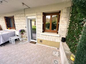 a house with a patio with a table and a window at Appartement calme Antony, terrasse, vue jardin, proche Paris et Orly in Antony