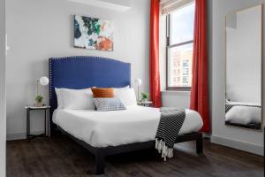 a bedroom with a blue and white bed and a window at Classy Studio Downtown Near Hard Rock Casino in Cincinnati