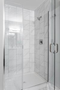 a shower with a glass door in a bathroom at Classy Studio Downtown Near Hard Rock Casino in Cincinnati