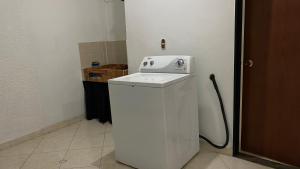 a small white washing machine in a room at Apartamento confortable y cálido in Itagüí +13 photos