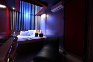 Hotel Karinho 2 في سانتو أندريه: غرفة مظلمة مع سرير وكرسي أسود