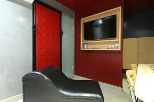 una silla de cuero negro en una habitación con TV en Hotel Karinho 2, en Santo André