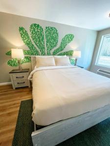 a bedroom with a bed with a cactus mural on the wall at Meadow Room At The Trailblazer Unit 7 in Townsend