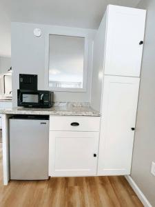 a kitchen with white cabinets and a microwave at Meadow Room At The Trailblazer Unit 7 in Townsend