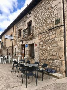 un gruppo di tavoli e sedie di fronte a un edificio di Elsoto a Quintana del Pidio