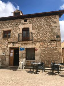 un edificio de piedra con mesas y sillas delante de él en Elsoto, en Quintana del Pidio