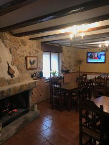 een eetkamer met een open haard en een tafel en stoelen bij Elsoto in Quintana del Pidio