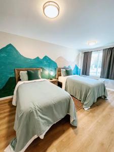 two beds in a room with a mural on the wall at Mountain Room At The Trailblazer Unit 16 in Townsend